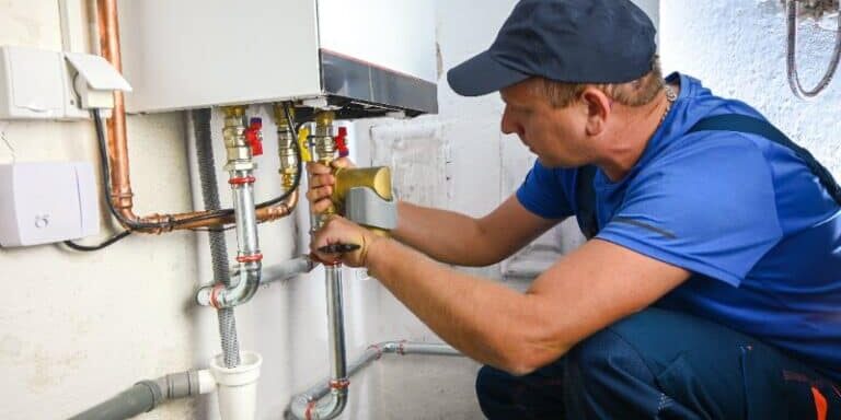 Professional plumber installing connection pipes for a heating system