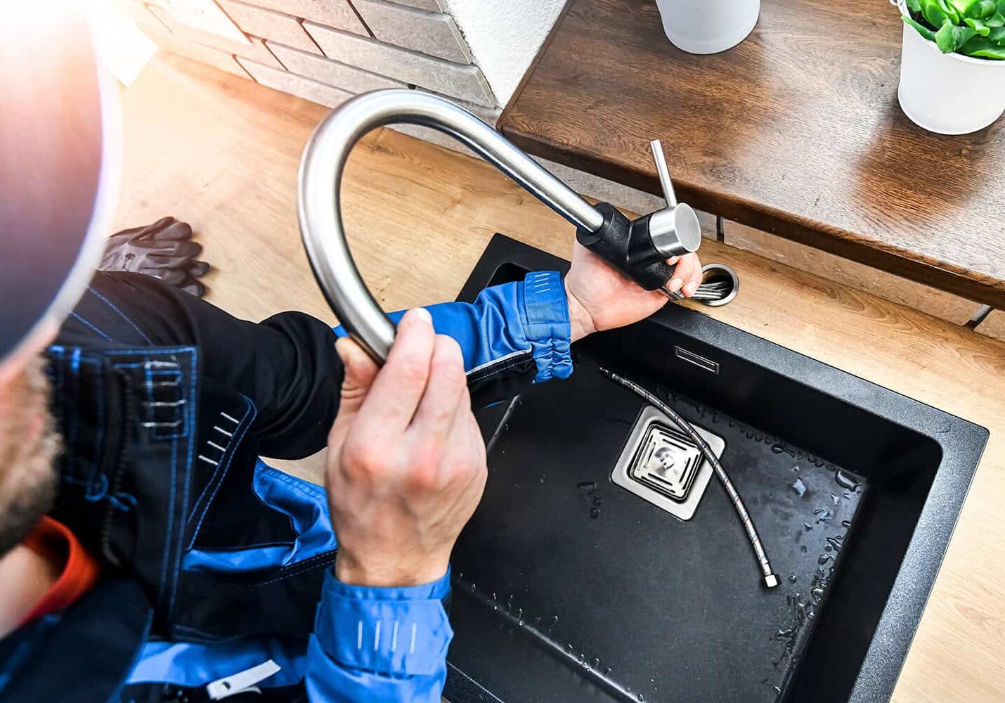 Water leak repair in kitchen sink by professional plumber.