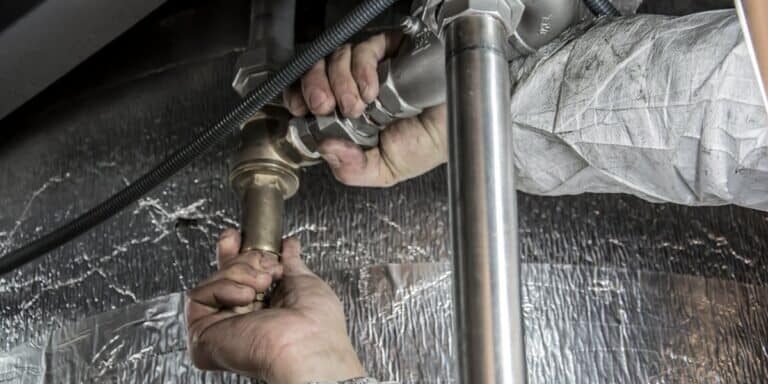 Plumber hands installing steel pipe fittings