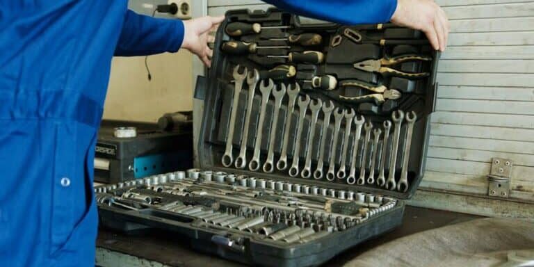 Professional plumber holding a toolbox with plumbing tools
